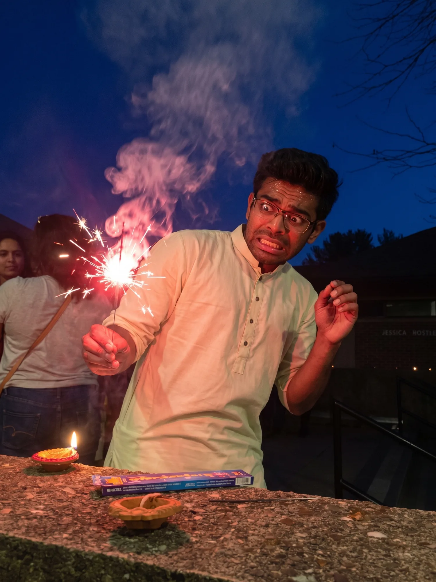 Abhijeet flinching from a sparkler at a nighttime gathering